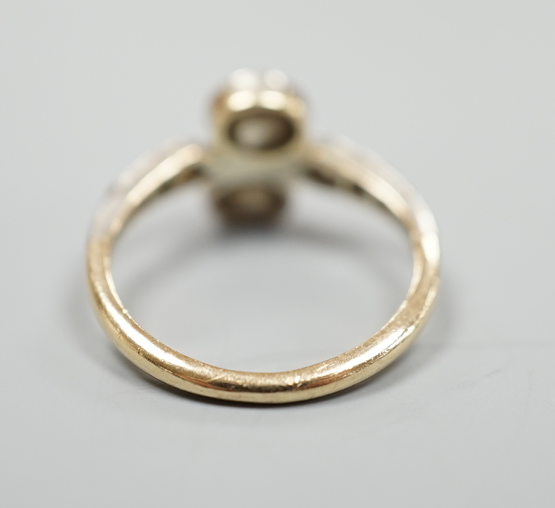 An antique yellow metal and two stone rose cut diamond set crossover ring, with diamond set shoulders, size L, gross weight 2.3 grams.